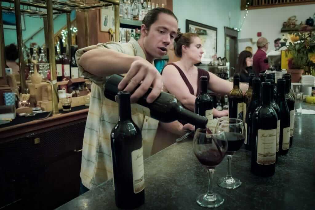 Austin Culver pouring wine at his whine bar